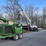 PrimeCut Tree Service Omaha crew with a large crane truck and an industrial wood chipper set up on a street for a tree removal job.